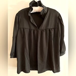 Cute black silky top with ruffle collar.  Pair with pants, skirts and leggings.